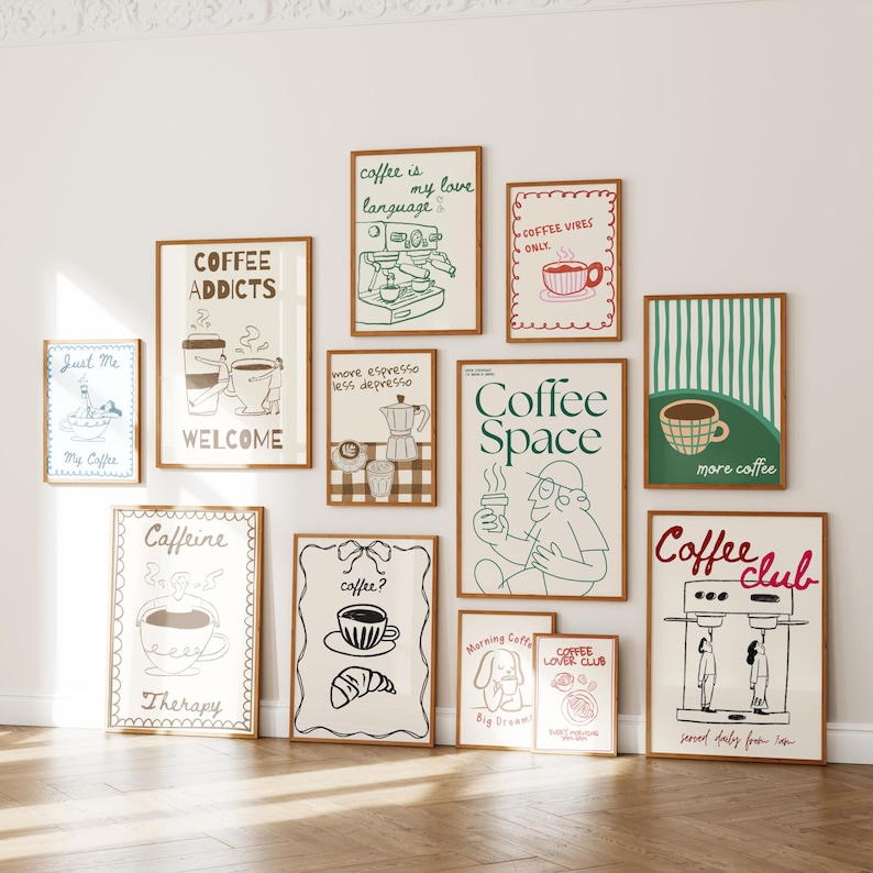 May include: A collection of framed art prints with coffee-themed illustrations and text. The prints feature drawings of coffee cups, espresso machines, and phrases like "Coffee Addicts" and "Coffee Space." The frames are a warm brown color.