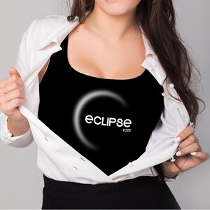May include: Black tank top with the word "ECLIPSE" in white, along with a crescent moon design and the year "2026". The tank top is being revealed by a white button-down shirt.