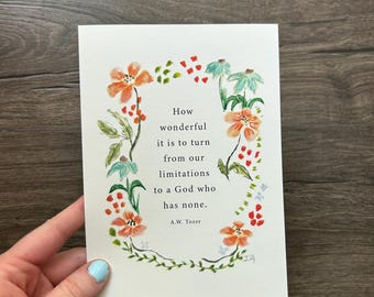 May include: A rectangular white greeting card featuring a watercolour floral wreath surrounding the printed text: How wonderful it is to turn from our limitations to a God who has none. A.W. Tozer. The flowers are painted in shades of orange, red, and teal.