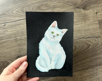 May include: A rectangular painting on a black background featuring a white cat with light blue shading and bright green eyes. The cat is depicted in a seated position, looking slightly to the side with its head tilted, rendered in a painterly style.