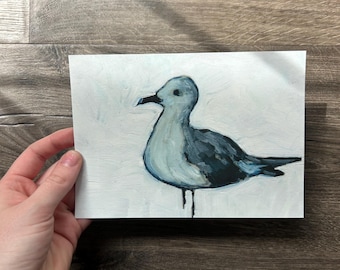 May include: A rectangular painting on paper featuring a seagull with a dark gray back and wings, a light gray chest, and a black beak. The bird is depicted in profile against a textured, off-white background with visible brushstrokes throughout the piece.