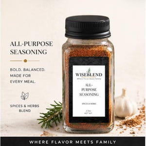 Puede incluir: Un frasco de vidrio transparente de condimento multiusos Wiseblend, con tapa y etiqueta negras. La etiqueta dice "All-Purpose Seasoning, Spices & Herbs Blend, 74g Net Wt." La imagen también incluye una ramita de romero y un bulbo de ajo.