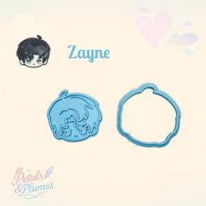 May include: A small enamel pin featuring a black-haired character named Zayne, alongside two light blue plastic cookie cutters. One cutter shows the character's face outline, and the other is a circular frame. The text Zayne is printed in blue.