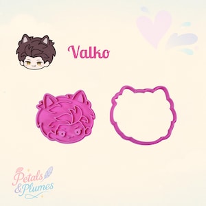 May include: A pink plastic cookie cutter set featuring a character with cat ears and a matching illustration labeled Valko. The set includes a detailed impression stamp and a separate outer cutting frame, both shaped like the character's head.