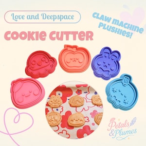 Puede incluir: Una colección de cortadores de galletas coloridos en varias formas, incluyendo una nube, una calabaza y un conejo. Los cortadores son rosas, naranjas y azules. La imagen también muestra galletas horneadas con las mismas formas. El texto en la imagen dice "Cookie Cutter".