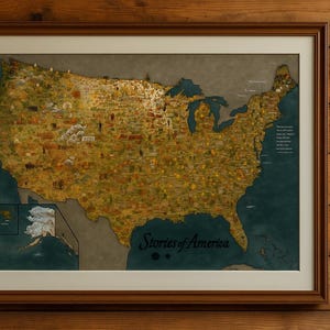 May include: Framed map of the United States with a detailed illustration of each state. The map is in a brown wooden frame and features the text "Stories of America". The map is set against a wooden background.