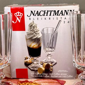 K&ouml;nnte beinhalten: Ein Set aus klaren Kristall-Irish-Coffee-Gl&auml;sern mit einer Schachtel mit dem Markennamen "NACHTMANN". Ein Glas ist mit Kaffee, Sahne und Sirup gef&uuml;llt. Die Schachtel enth&auml;lt Text in mehreren Sprachen, darunter "Irish Coffee-Gl&auml;ser".
