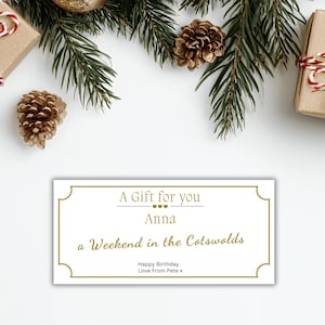 Puede incluir: Un vale de regalo con texto y borde dorados, que dice "A Gift for you Anna a Weekend in the Cotswolds Happy Birthday Love From Pete x." La tarjeta está rodeada de ramas de pino, piñas y regalos envueltos.