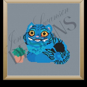 May include: Cross-stitch art of a blue cat with yellow eyes and a mischievous grin, set against a gray background. The cat has black markings and is next to a small potted plant. The artwork is framed in a gold-colored frame.