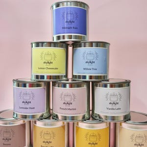 May include: A display of ten scented candles in metal tins. Each tin features a label with the "skylight" logo and a flavour name: Midnight Rain, Lemon Cheesecake, Willow Tree, Lavender Haze, French Martini, Vanilla Latte, S'mores, Banoffee Pie, Mango Sorbet, and Shortbread.