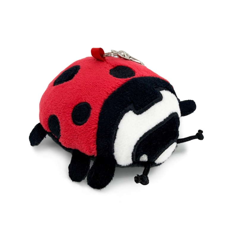 Peut inclure: Porte-cl&eacute;s coccinelle en peluche rouge et noir avec des taches noires. La coccinelle a un visage blanc et de petites pattes et antennes noires. Une petite boucle rouge et un porte-cl&eacute;s argent&eacute; sont attach&eacute;s.