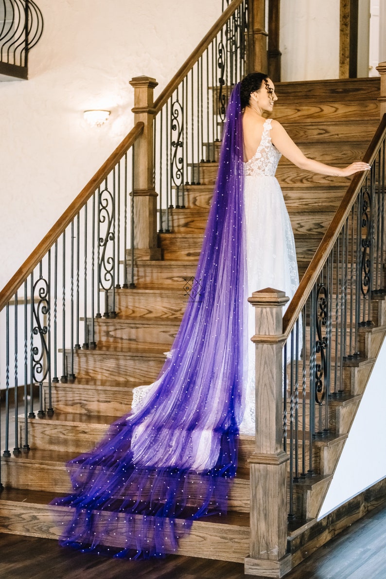 A single-layer oval shape veil made from a lightweight, ultra soft tulle covered in pearl stud beads. Shown in Royal Purple.