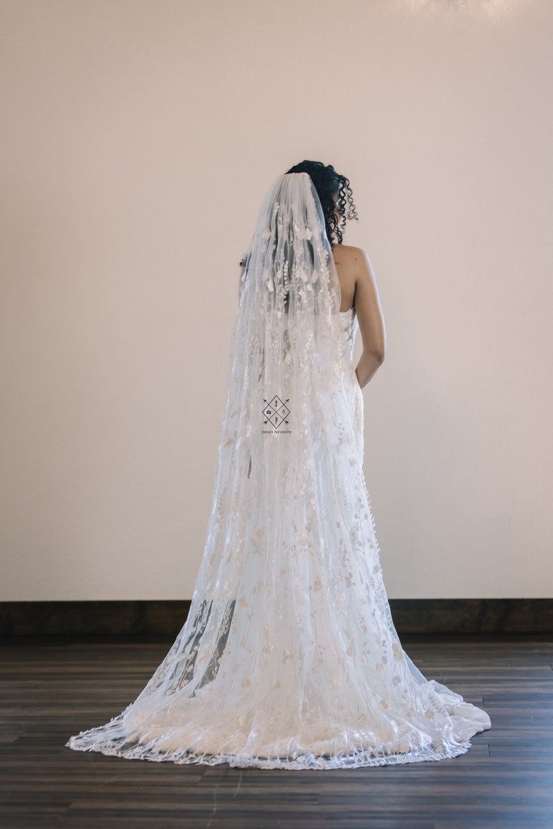 A single-layer oval veil made from a ivory floral embroidered lace on a light ivory tulle.