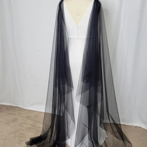 A pair of detachable cape veil  attached to either shoulder. They are an asymmetrical cascading shape. Shown in black.