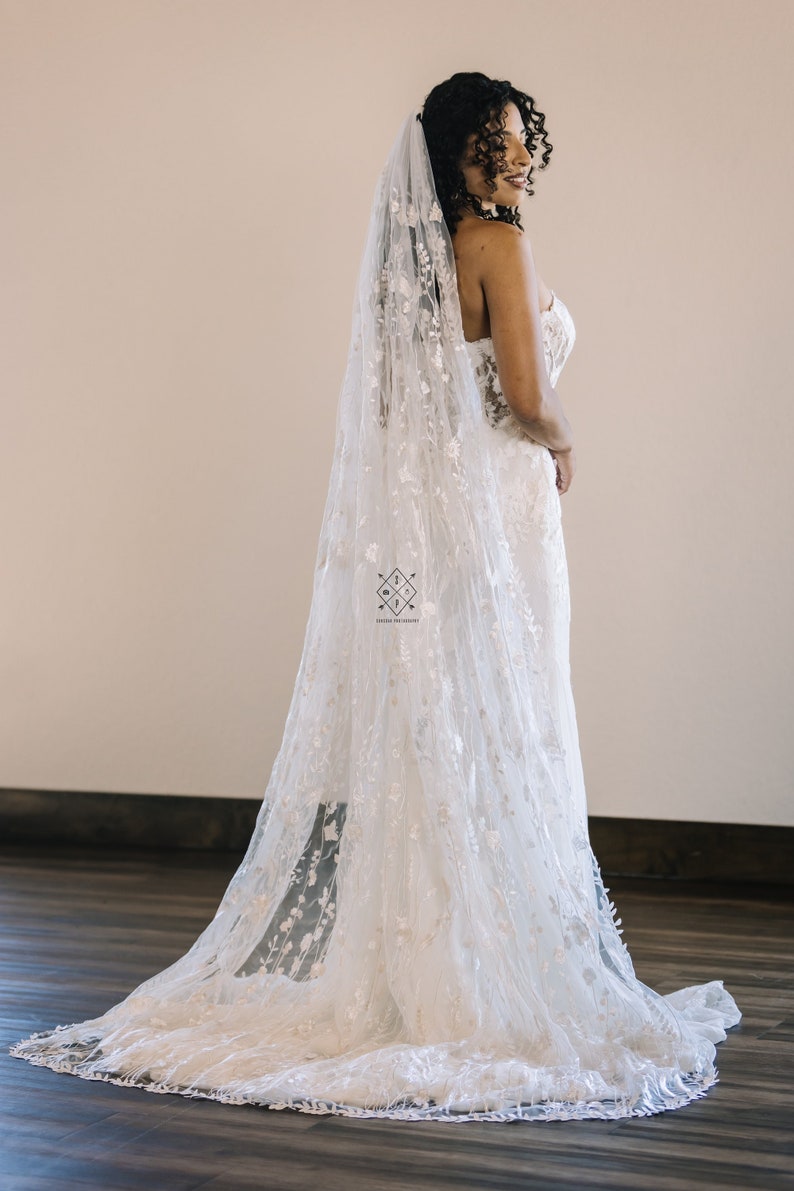 A single-layer oval veil made from a ivory floral embroidered lace on a light ivory tulle.