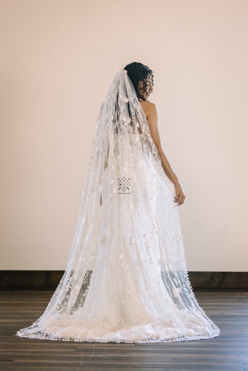 A single-layer oval veil made from a ivory floral embroidered lace on a light ivory tulle.