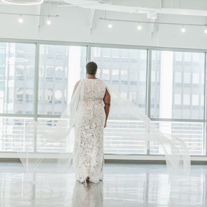 A pair of detachable cape veil  attached to either shoulder. They are an asymmetrical cascading shape. Shown in Lt Ivory.
