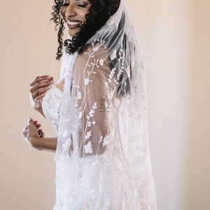 A single-layer oval veil made from a ivory floral embroidered lace on a light ivory tulle.