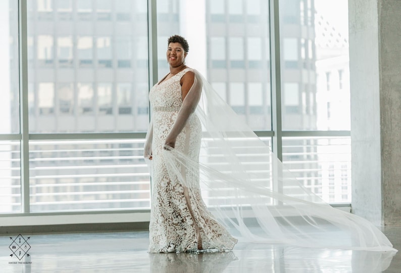 A pair of detachable cape veil  attached to either shoulder. They are an asymmetrical cascading shape. Shown in Lt Ivory.