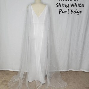 A pair of detachable cape veil  attached to either shoulder. They are an asymmetrical cascading shape. Shown in Shiny White.