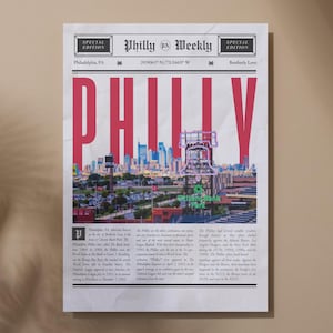 May include: A newspaper-style print with the headline "PHILLY" in large, red letters. The image features a cityscape with a baseball stadium and the text "Citizens Bank Park". The print has a vintage aesthetic.