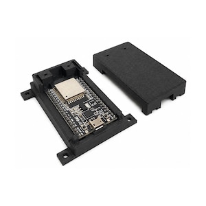 Könnte beinhalten: Ein schwarzes, 3D-gedrucktes rechteckiges Gehäuse für ein elektronisches Entwicklungsboard. Die Basis enthält eine Leiterplatte mit einer silbernen Metallabschirmung, einem Micro-USB-Anschluss und einem mit Boot beschrifteten Knopf. Ein passender schwarzer, texturierter Deckel liegt daneben.
