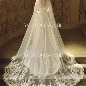 Könnte beinhalten: Ein weißes Brautkleid mit einem langen, fließenden Schleier. Der Schleier und das Kleid sind mit aufwendigen Spitzendetails verziert. Der Text "YOUR DREAM VEIL" ist auf dem Bild aufgedruckt.