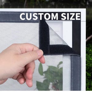 May include: A black mesh screen with a velcro border, labelled "CUSTOM SIZE" in white text. The screen is partially peeled back, revealing the mesh and a glimpse of greenery. The screen is designed to fit a window or door.
