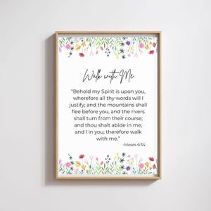 May include: A framed print with a light wood frame. The print features the text "Walk with Me" in elegant script above a quote from Moses 6:34. The top and bottom of the print are decorated with watercolor flowers.