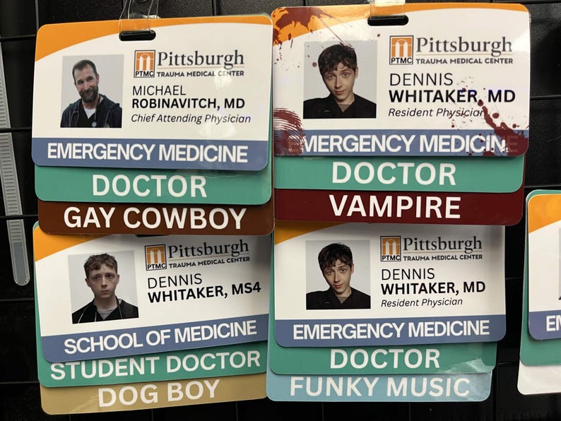 May include: Several name badges from the Pittsburgh Trauma Medical Center are displayed. Each badge includes a photo, name, and title, such as "Chief Attending Physician" and "Resident Physician." Additional text includes "Emergency Medicine," "Doctor," and humorous phrases.