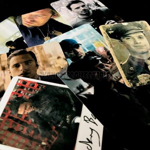 May include: A collection of glossy trading cards featuring various actors in different poses. The cards have a vintage aesthetic, with some appearing to be aged. The images are primarily in black and white and sepia tones, with some color accents.