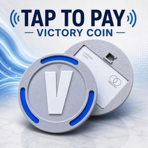 May include: A circular gray Victory Coin with a large white letter V and blue accents, featuring a contactless payment symbol. The coin is positioned in front of a matching gray circular holder containing a white California Series Mastercard.
