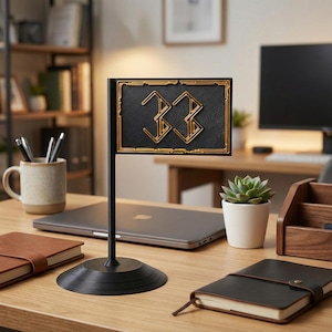 May include: A black desk flag with the number "33" in gold. The flag is rectangular with a gold border and is mounted on a black pole and base. The flag is on a wooden desk with a laptop, notebooks, and a small potted succulent.