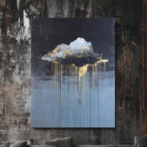 May include: Abstract cloud painting in dark blue and gold. The artwork depicts a cloud with gold detailing and gold drips against a blue and dark blue backdrop. The painting is displayed in a contemporary living room setting.