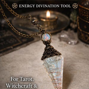 May include: An Opalite Pendulum featuring a 9-inch brass chain, a copper coil, and a resin chamber. The text reads: Opalite Pendulum, 9" Brass Chain, Copper Coil, Resin Chamber, ENERGY DIVINATION TOOL, For Tarot, Witchcraft & Spiritual Guidance.