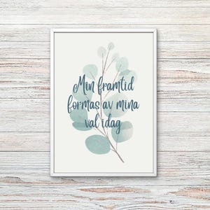 Peut inclure: Une affiche encadrée avec un motif d'eucalyptus à l'aquarelle dans des tons verts et bleus. L'affiche présente le texte "Min framtid formas av mina val idag" en écriture cursive, sur fond crème. Le cadre est blanc.