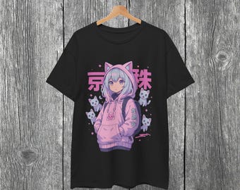 May include: Black t-shirt featuring an anime-style illustration of a girl in a pink cat-ear hoodie, surrounded by white cat figures. Japanese text is above the character. The shirt is hanging on a wooden hanger.