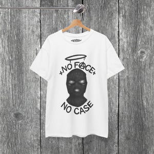 Maglietta "No Face No Case", T-shirt streetwear con passamontagna, T-shirt con grafica Urban Mask, Top con alone di angelo grunge, Estetica dark edgy