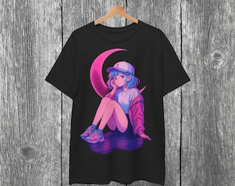 May include: Black t-shirt featuring an anime-style illustration of a girl with blue hair and a pink jacket, sitting on a pink crescent moon. The girl wears a baseball cap and sneakers. The design is centered on the shirt.