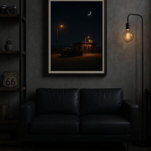 May include: Framed art print depicting a nighttime scene with a crescent moon and a building with the word "GAO" illuminated. A car is parked in front of the building. The print hangs above a black leather sofa. A Route 66 sign is visible on a shelf.