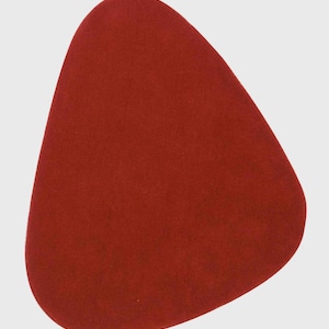 May include: A solid dark red placemat with an irregular, rounded triangular shape and smooth, matte edges. The object features a uniform, deep crimson colour throughout its entire surface, presenting a simple, flat, and non-textured appearance.