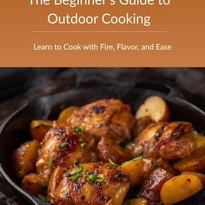 May include: Image of a cookbook cover titled "Fire At Home" with the subtitle "The Beginner's Guide to Outdoor Cooking." The image shows cooked chicken and potatoes in a cast iron skillet over a grill. The text reads "Learn to Cook with Fire, Flavor, and Ease."