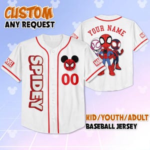 May include: White baseball jersey with red trim and accents. The front features the word "SPIDEY" in red, a Spider-Man-themed logo, and the number "00". The back displays a Spider-Man graphic and the text "YOUR NAME". The jersey is available in kid, youth, and adult sizes.