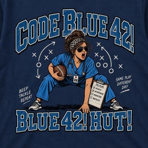 Può includere: Una t-shirt blu navy con la grafica di una persona in divisa medica blu, occhiali da sole e fascia, che tiene un pallone da football e una cartellina. Il testo recita CODE BLUE 42, BLUE 42 HUT, BEEP TACKLE REPEAT e SAME PLAY DIFFERENT DAY.