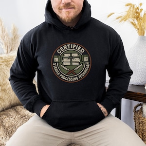 May include: Black hooded sweatshirt with a circular graphic. The graphic reads "CERTIFIED STERILE PROCESSING TECHNICIAN" in a circular design with a medical theme. The design includes a package, knives, and other medical equipment.
