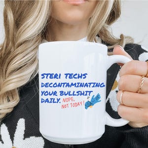 May include: White ceramic mug featuring the text "STERI TECHS DECONTAMINATING YOUR BULLSHIT DAILY. NOPE, NOT TODAY!" in blue and red. A blue gloved hand graphic is also on the mug.