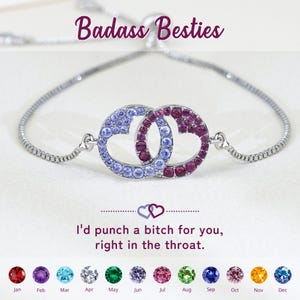 Könnte beinhalten: Ein verstellbares silberfarbenes Armband mit zwei ineinandergreifenden kreisförmigen Anhängern, die mit hellblauen und dunkelrosa Kristallen besetzt sind. Der Text "Badass Besties" und "I'd punch a bitch for you, right in the throat." steht über und unter dem Schmuckstück.