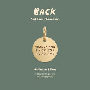 May include: A gold-colored, round pet tag with a ring for attachment. The tag is engraved with the word "MICROCHIPPED" and two phone numbers. The text "BACK Add Your Information" is above the tag.