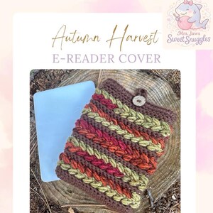 May include: Crocheted e-reader cover with an autumn harvest theme. The cover features a woven design in shades of brown, red, orange, and green, secured with a button closure. The text "Autumn Harvest E-READER COVER" is displayed.