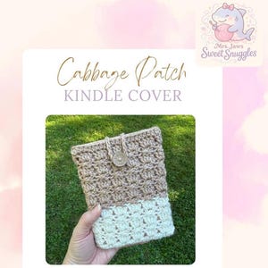 May include: A handmade Kindle cover in a two-tone crochet design. The top portion is a light brown, and the bottom is off-white. The cover is secured with a button closure. The text "Cabbage Patch KINDLE COVER" is displayed at the top.